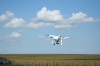 A drone hovers over a farm