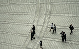 office workers cross a downtown plaza in Tokyo