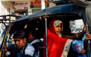 A woman rides in the back of an auto-rickshaw in Uttar Pradesh, India.