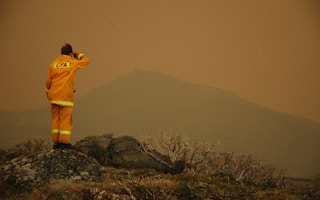 A firefighter in Falls Creek, Victoria, Australia looks across the smog generated by wildfires. 