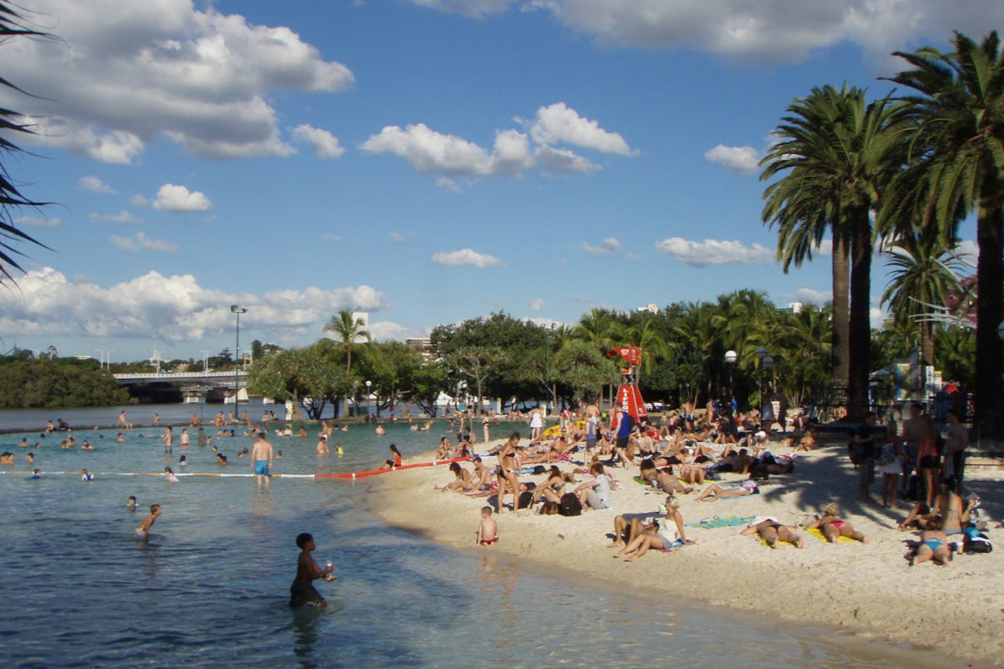 Sun seekers bask in the afternoon glow on a man-made beach in Brisbane