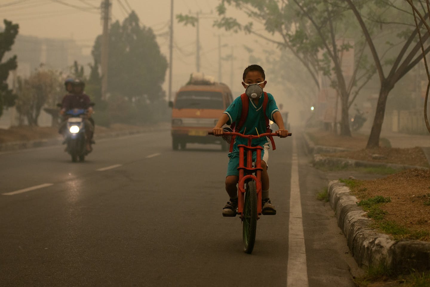 boy biking pollution indonesia