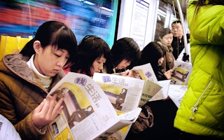 Chinese commuters catch up on news in metro