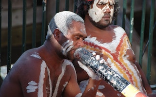 Australian aborigine plays a didgeridoo