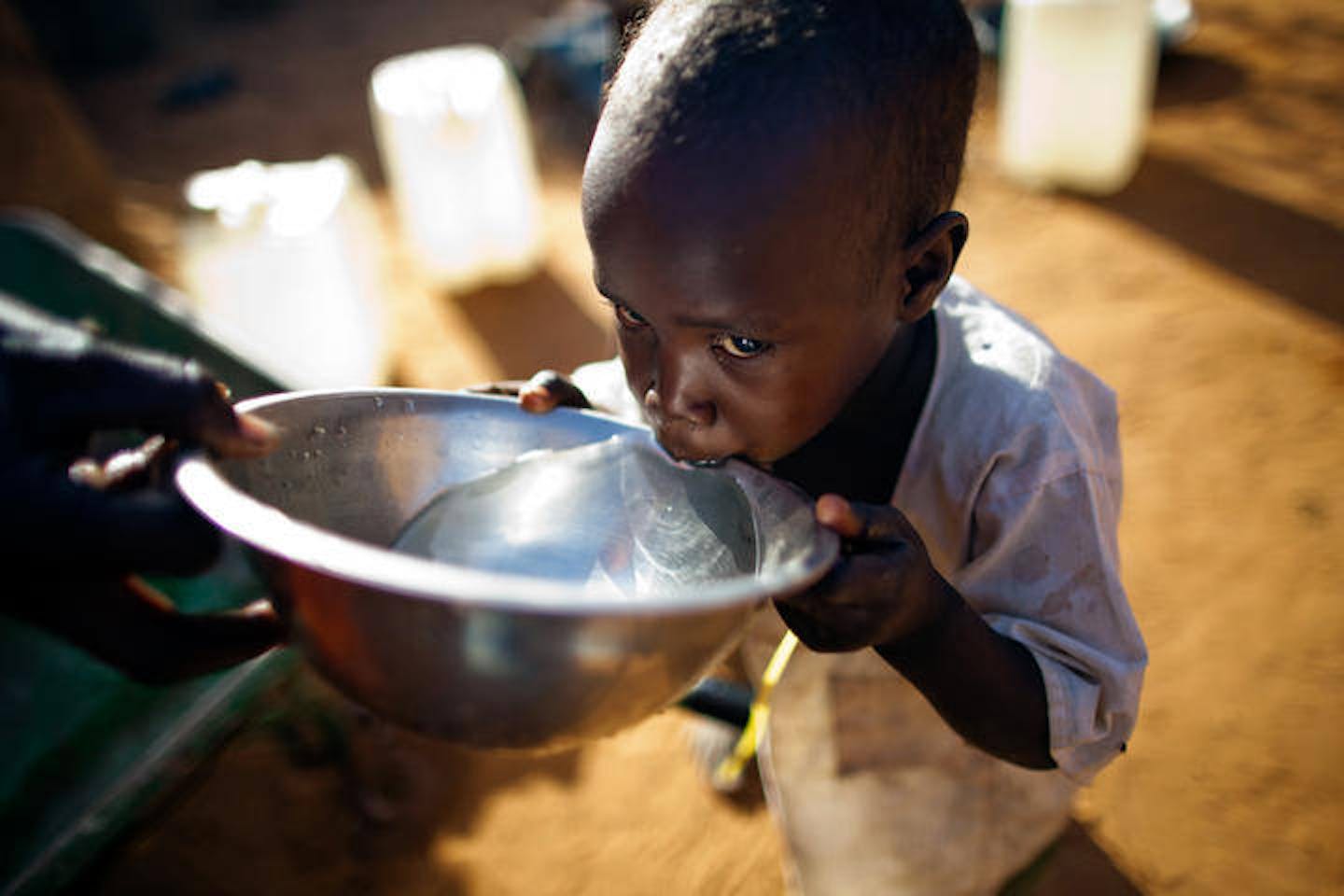 child receives a drink of water in Sudan