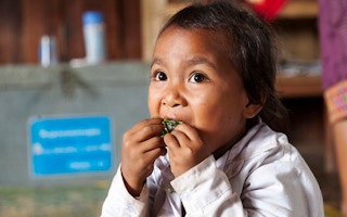child eats in Laos