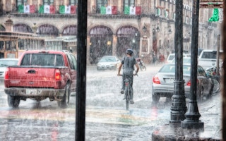 boy riding bike in the rain