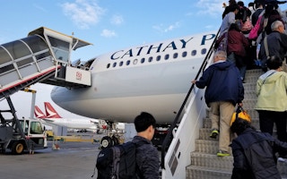 Travellers board a Cathay Pacific flight