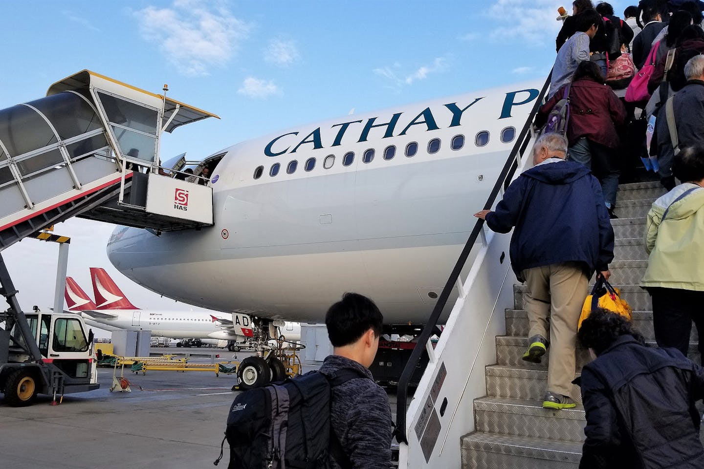 Travellers board a Cathay Pacific flight