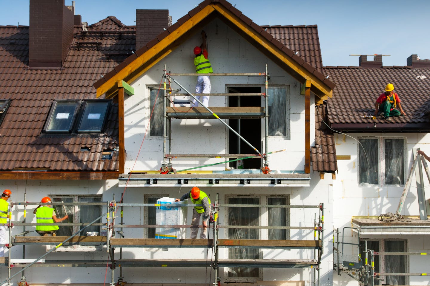 Builders work together to finish a house.