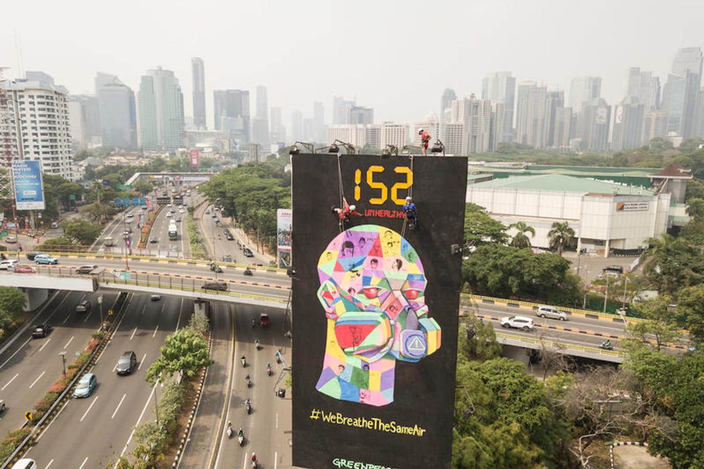 Greenpeace activists hang clean air campaign billboard in