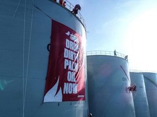 Drone image shows Greenpeace activists unfurling a banner reading "Drop Dirty Palm Oil Now" at the Wilmar International refinery in Bitung, North Sulawesi.