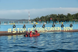 Greenpeace activists paint "Stop Deforestation Now" onto the hull of a palm oil tanker at the Wilmar International refinery in Bitung, North Sulawesi.