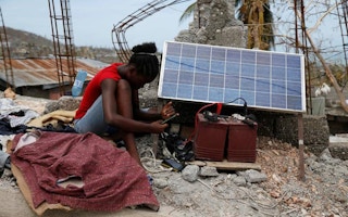 woman charging phone through solar panels