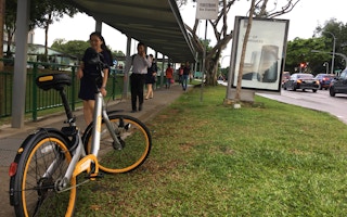 An Obike bicycle is left by a busy walkway near Kent Ridge train station in Singapore. The explosion in use of smart bike-sharing schemes has concerned Singapore's tidiness-conscious government. Image: Eco-Business