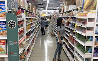 Choosing the responsible food option? A customer a supermarket in Singapore reaches for an item. Image: Eco-Business