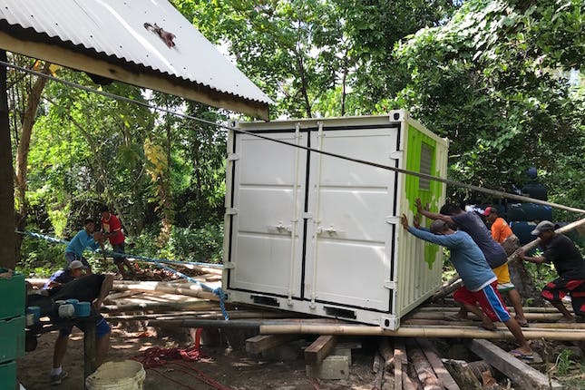 Workers at Qi Palawan resort setting up a solar energy system