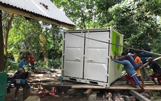 Workers at Qi Palawan resort setting up a solar energy system