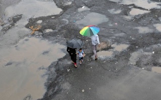 people carrying umbrellas after a storm in India