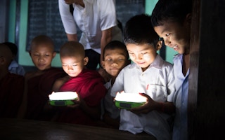 Children in Myanmar hold a solar lamp provided by Panasonic