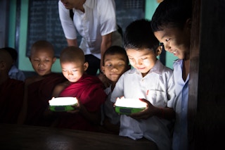 Children in Myanmar hold a solar lamp provided by Panasonic