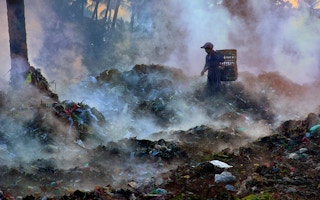 A girl sifts through trash in Nyaung U, Myanmar