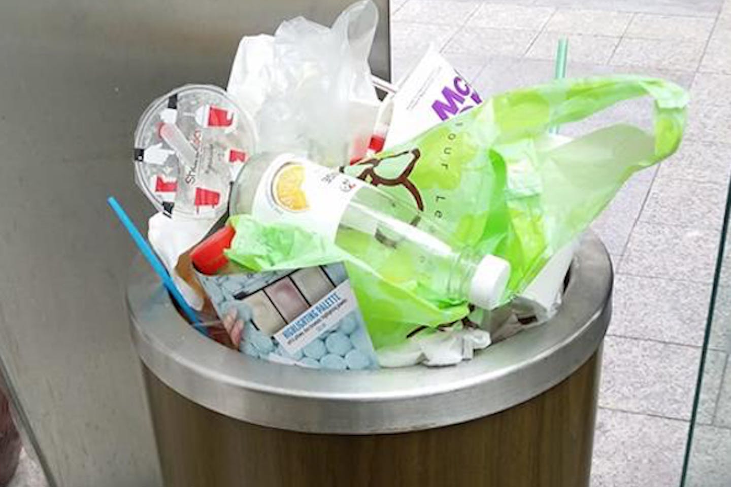 Plastic trash piles on top of a rubbish bin in downtown Singapore.