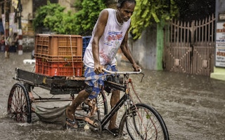 man cycles floodwater