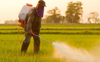worker spraying herbicide