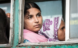 A woman in Dhaka looks out forlornly. 