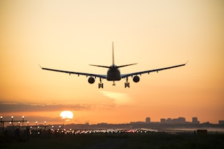 airplane lands during sunrise