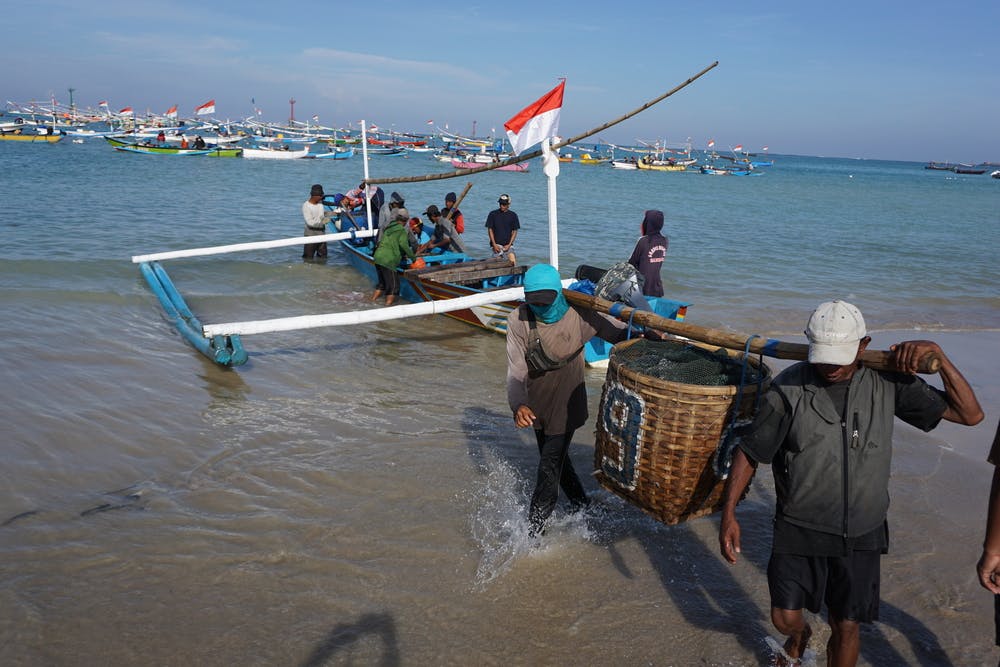 fishermen carry baskets in Indonesia