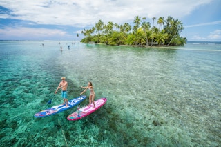 Stand up paddling against very clear waters