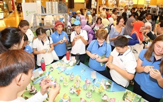 Students from the International School of Kuala Lumpur learning how to turn used cartons into decorative trees at Sunway Pyramid on 11 November 2016.
