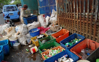 Waste collector in Indonesia segregating trash