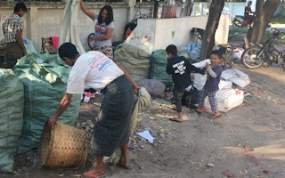 Children play with informal waste pickers in Myanmar